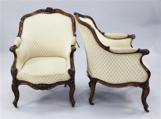 A pair of Louis XV style carved walnut bergere chairs,